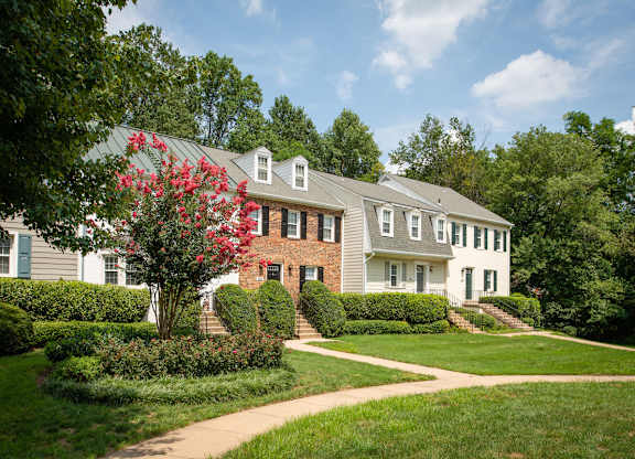 A white house with a red roof and a green lawn at Fairfax Square Apartments, Virginia