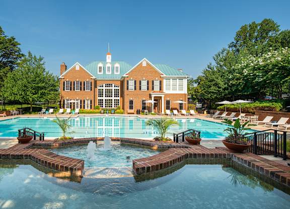A large building with a pool in front of it. at Fairfax Square Apartments, Virginia, 22031