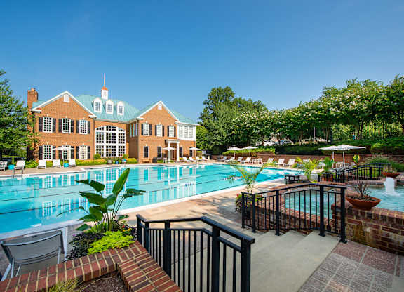 A large pool with a brick wall and a building behind it at Fairfax Square Apartments, Virginia, 22031
