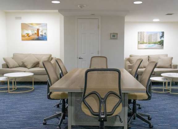 A conference room with a long table surrounded by chairs.