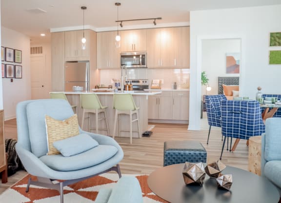 a living room and kitchen with blue chairs and a table at Makers Rise, Herndon, VA  