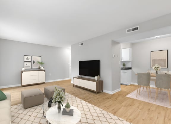 a living room with a table and chairs and a television at West Pointe Apartments in Burlington, NC