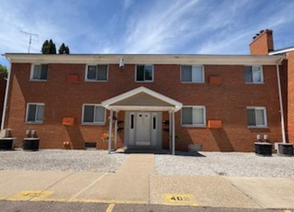 A red brick building with a white door and windows.
