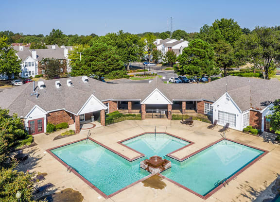 A large swimming pool surrounded by a building and trees at The Trails at Mt. Moriah, Tennessee 38115