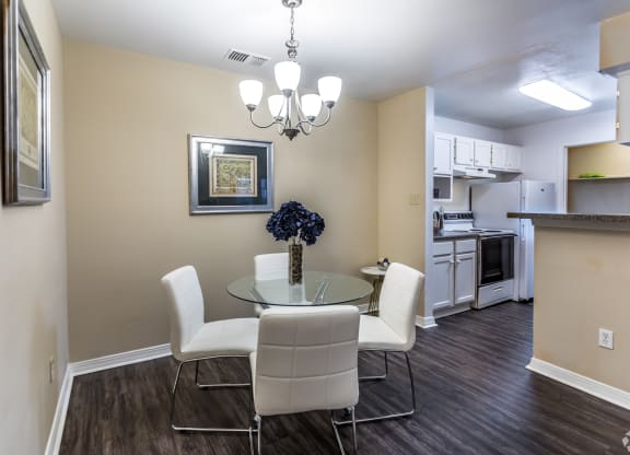 a dining room with a glass table and chairs and a kitchen at The Trails at Mt. Moriah, Tennessee 38115