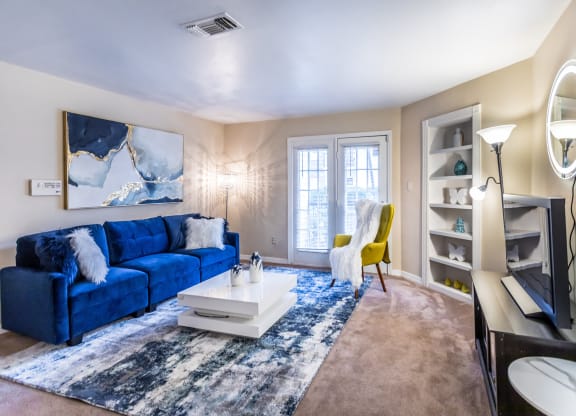 a living room with a blue couch and a white coffee table at The Trails at Mt. Moriah, Memphis