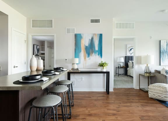 A modern kitchen with a bar area and a living room with a couch.