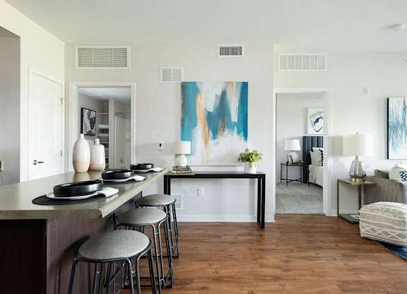 A modern kitchen with a bar area and a living room with a couch.