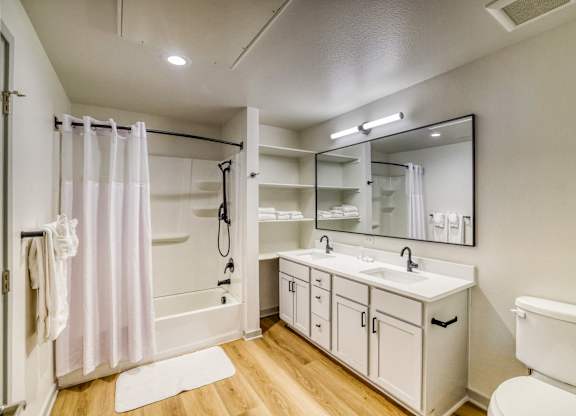 A white bathroom with a white toilet, sink, and bathtub.