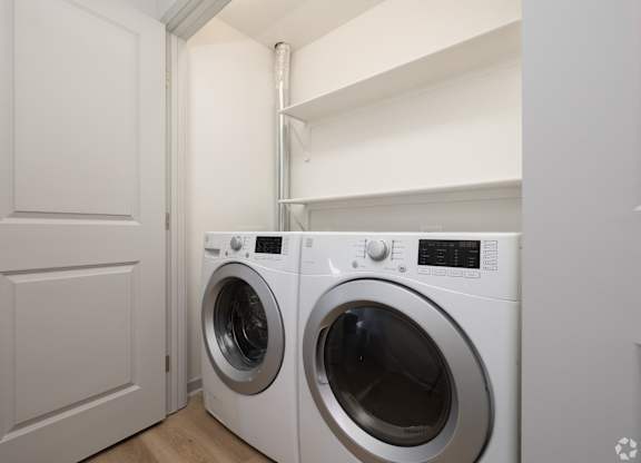 A white washing machine sits in a laundry room.
