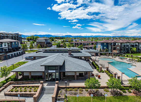 A large building with a pool in front of it.