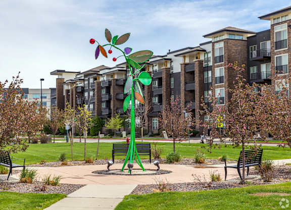A playground with a green slide and a red apple-shaped slide.