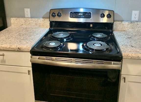 A stainless steel stove with a microwave above it in a kitchen.