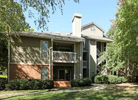 A two-story house with a balcony on the second floor.