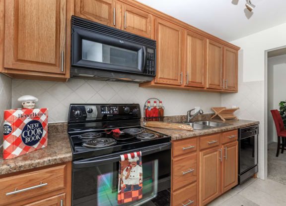 a kitchen with wooden cabinets and black appliances