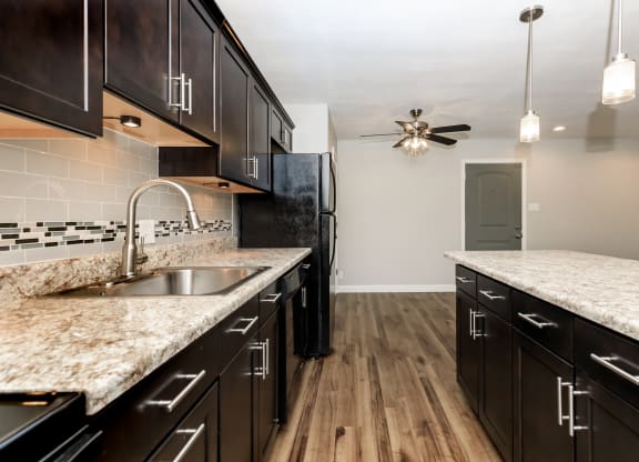a kitchen with dark cabinets and white countertops