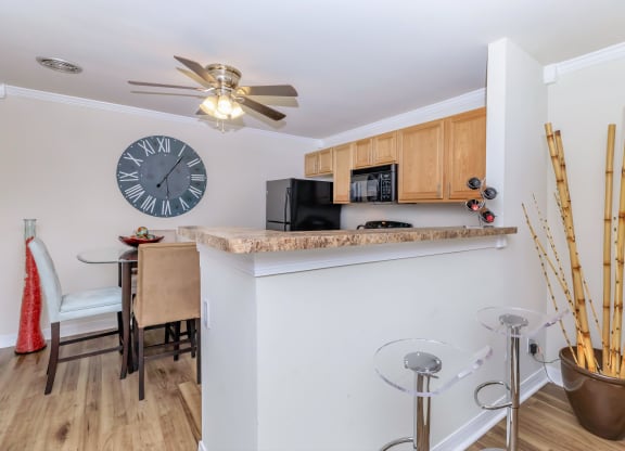 a kitchen and dining area with a large clock on the wall