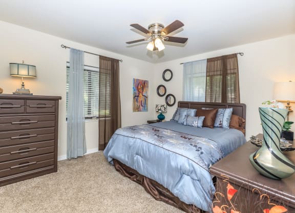 a bedroom with a large bed and a ceiling fan