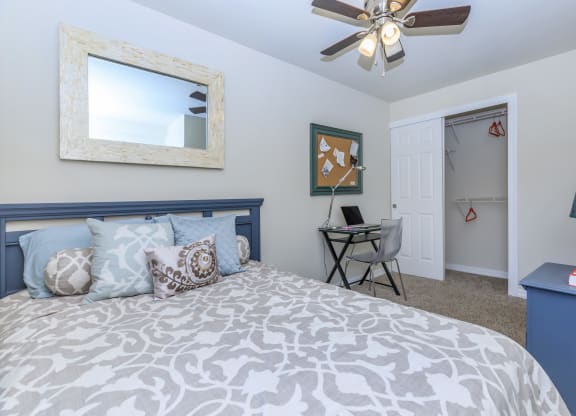 a bedroom with a bed and a ceiling fan