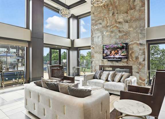 A modern living room with a stone pillar and a flat screen TV mounted on it at Alinea Town and Country Luxury Apartments in Des Peres MO 63131..