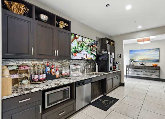 A kitchen with dark brown cabinets and a white counter top at Alinea Town and Country Luxury Apartments in Des Peres MO 63131.
