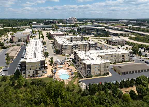 A large apartment community of buildings with a pool in the middle at Alinea Town and Country Luxury Apartments in Des Peres MO 63131..