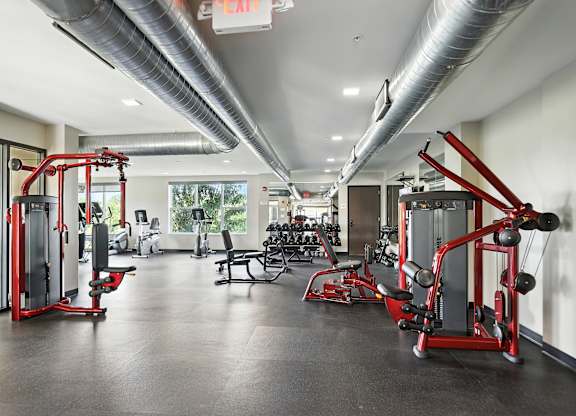 A gym with a variety of equipment including a leg press machine at Alinea Town and Country Luxury Apartments in Des Peres MO 63131.