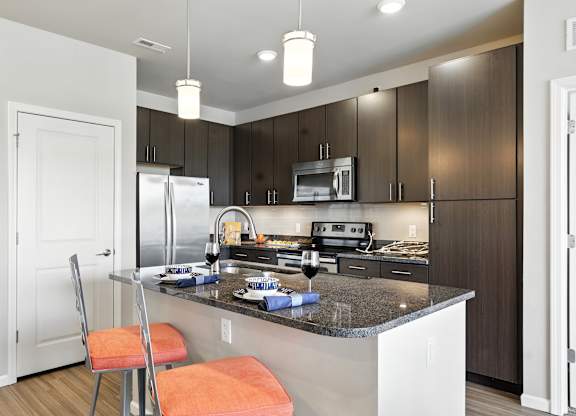 A kitchen with a white counter top and a refrigerator at Alinea Town and Country Luxury Apartments in Des Peres MO 63131.