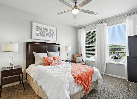A bedroom with a large bed and a ceiling fan at Alinea Town and Country Luxury Apartments in Des Peres MO 63131..