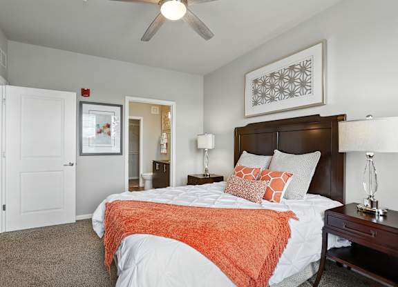A bedroom with a bed, nightstand, and a ceiling fan at Alinea Town and Country Luxury Apartments in Des Peres MO 63131..