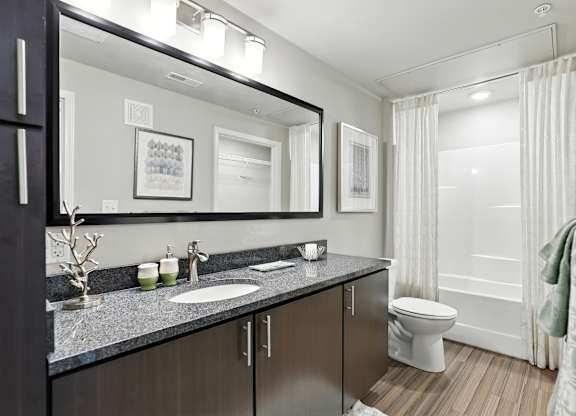 A bathroom with a white toilet and a sink at Alinea Town and Country Luxury Apartments in Des Peres MO 63131..