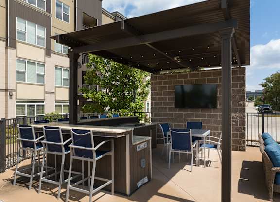 A patio with a table and chairs under a roof at Alinea Town and Country Luxury Apartments in Des Peres MO 63131..