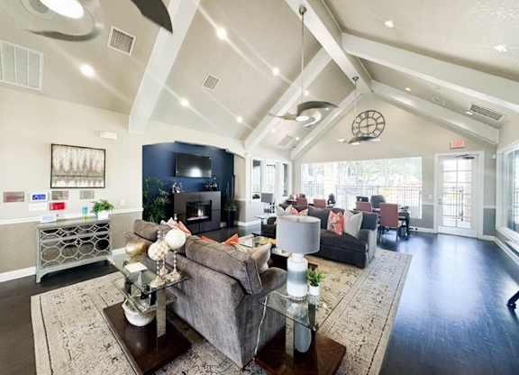 A living room with a grey couch and a fireplace.