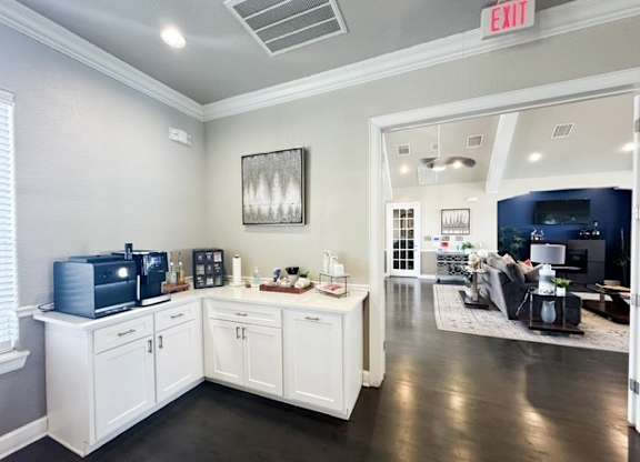 A room with a white cabinet and a framed picture on the wall.
