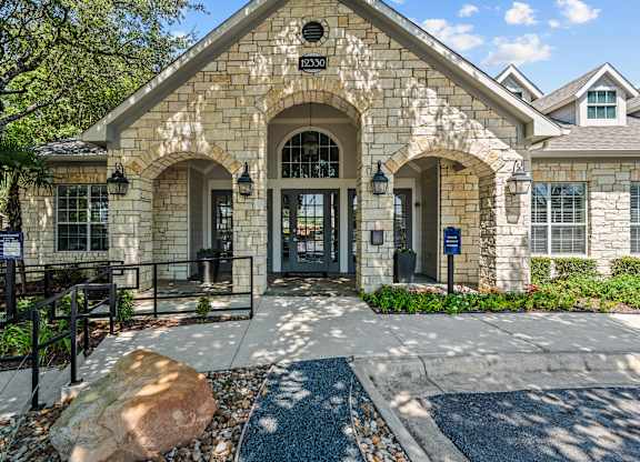 A building with a stone facade and a black gate in front.