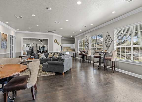 A spacious living room with a dining area and a kitchen in the background.