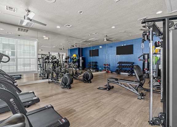 A gym with treadmills, weights, and exercise equipment.