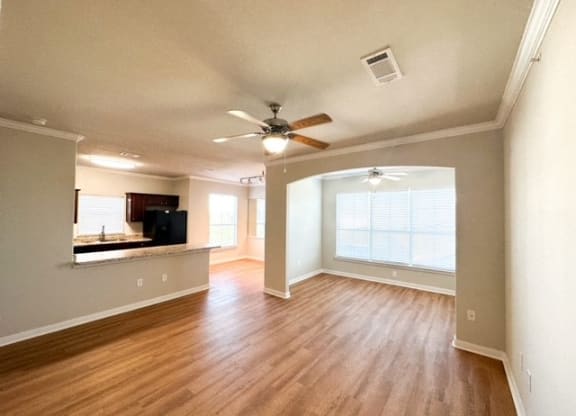 an empty living room with a ceiling fan