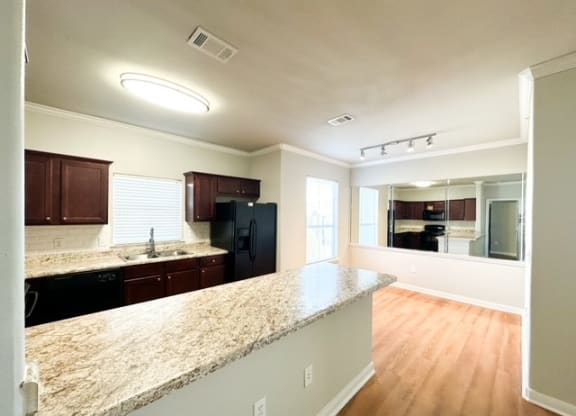 an empty kitchen with a granite counter top