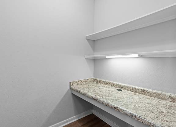 A bathroom with a counter top and a light on.