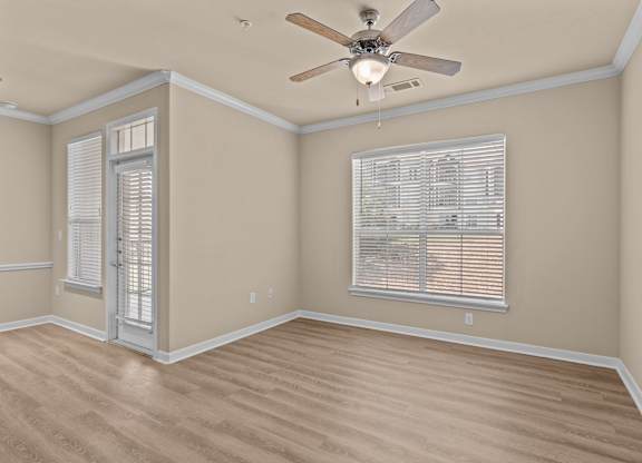A room with a ceiling fan and a window with blinds.