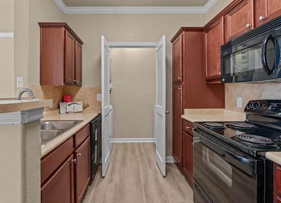 A kitchen with brown cabinets and a black stove top oven.