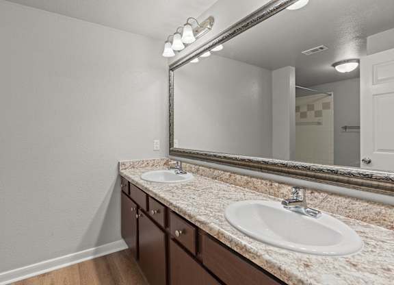 A bathroom with a sink, mirror, and lights.