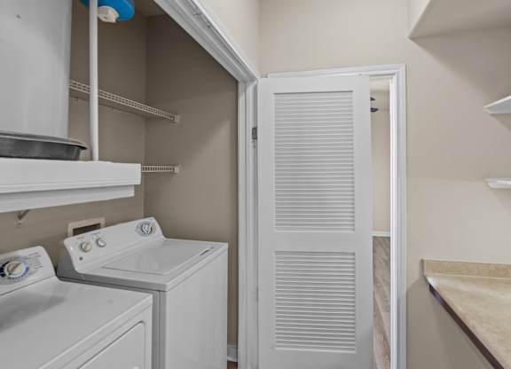 A white washing machine and dryer in a small laundry room.