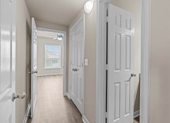 A hallway with white doors and a light on the ceiling.