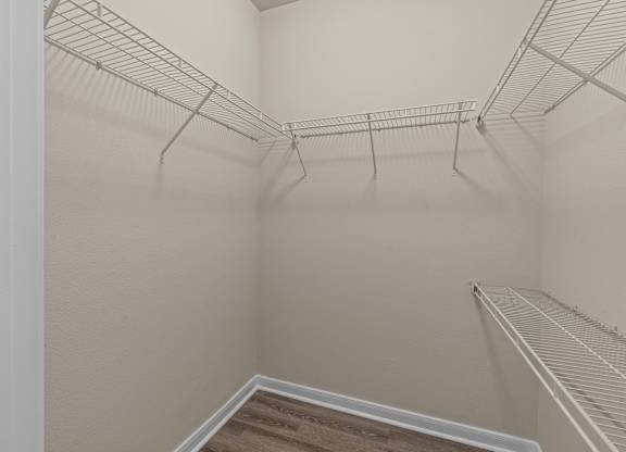 Empty white closet with shelves and a staircase.