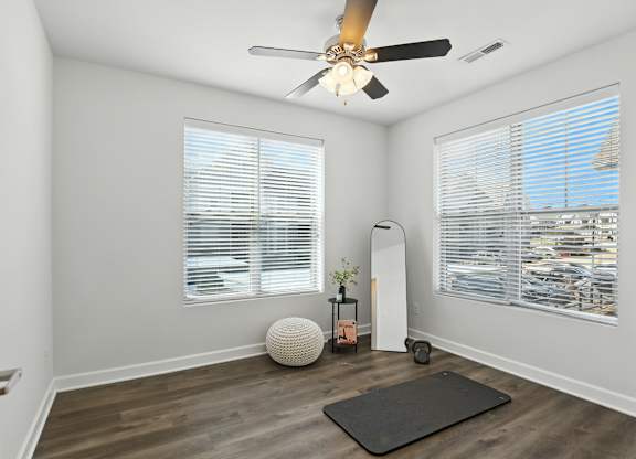 A room with a ceiling fan and a yoga mat on the floor at Bramblett Hills Luxury Apartments in O Fallon MO 63366
