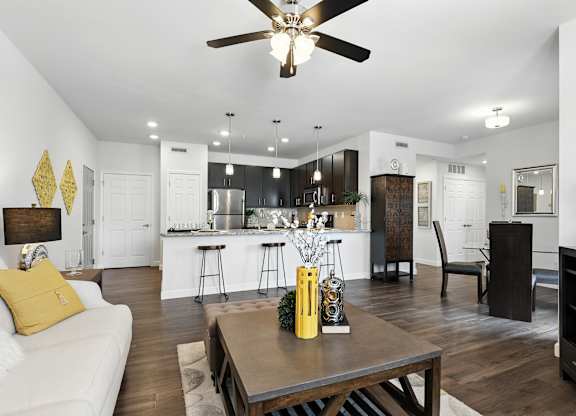 A modern kitchen with a white couch and a wooden table at Bramblett Hills Luxury Apartments in O Fallon MO 63366