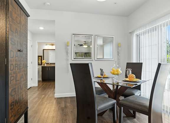 A dining room with a glass table and chairs at Bramblett Hills Luxury Apartments in O Fallon MO 63366