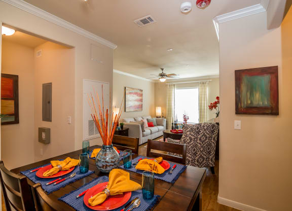 a dining area with a wooden table and chairs and a living room with a couch an